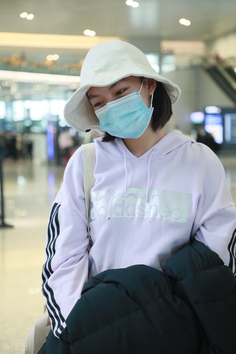 文淇一袭白色连帽卫衣现身机场，头戴帽子遮不住甜甜的笑容